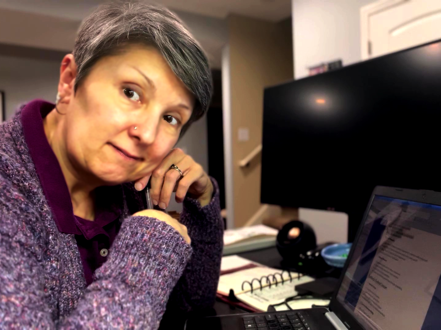 A woman leans over her keyboard