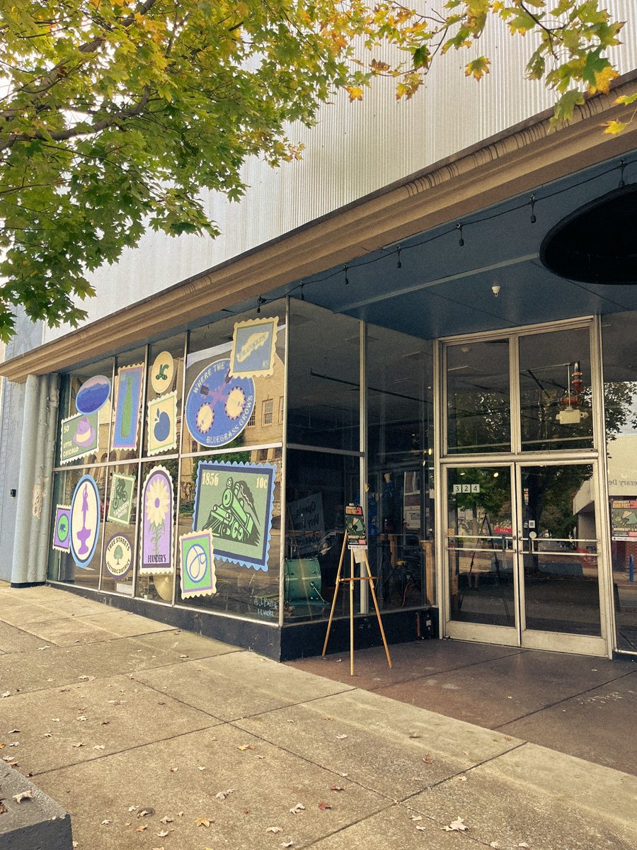 Front entrance of 324 Main Street, Johnson City Zine Fest venue with fall leaves overhead.