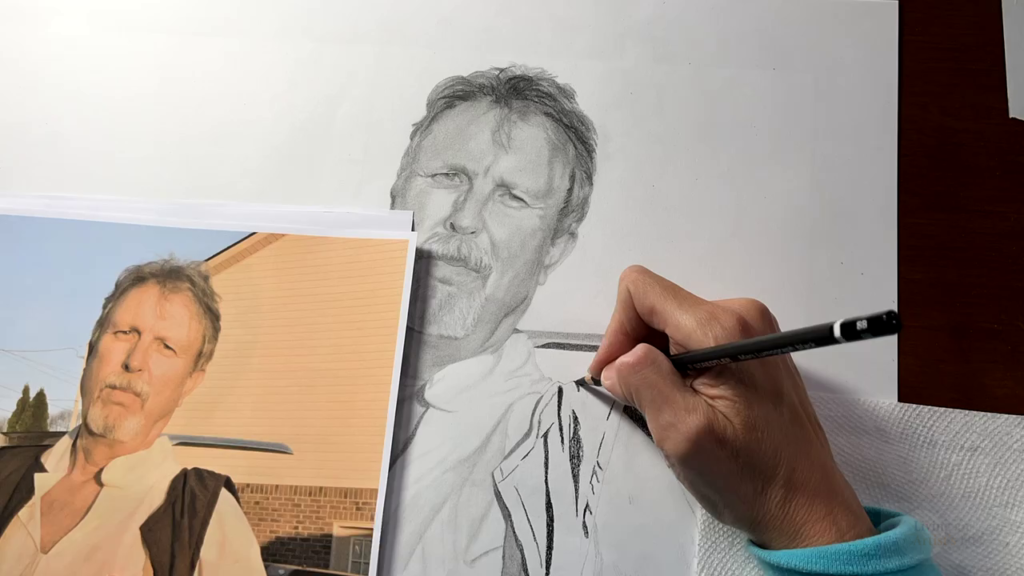 An artist's hand using a pencil and drawing a man in medieval clothing 