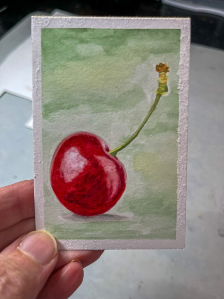 A small watercolor painting of a red cherry on a pale green background.