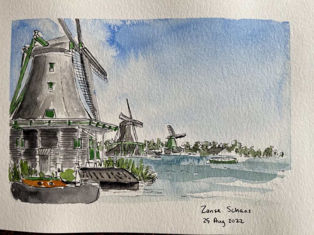 Mixed media sketchbook painting of windmills along the water at Zaanse Schans, with pen linework, watercolor washes, and handwritten date notes.