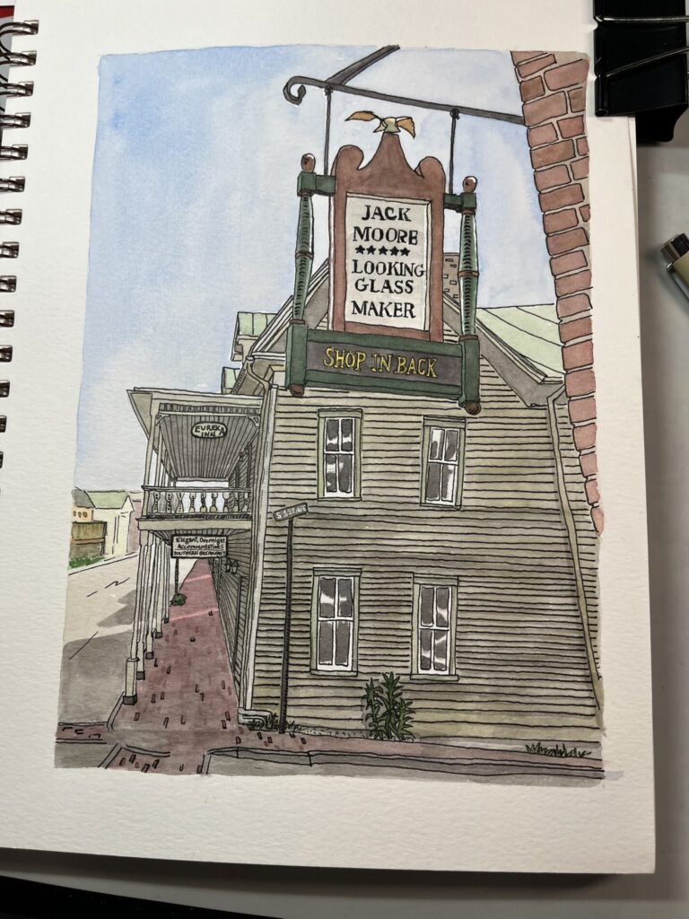 Earlier watercolor and ink painting of Jack Moore’s Looking Glass Maker sign above a wonky gray building beside the Eureka Inn in Jonesborough.